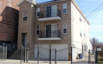 Newark apartment for rent - A large two-story building with a balcony on the second floor.
