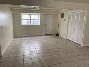 Newark apartment for rent - A room with white walls and tile flooring, with a window and a door.
