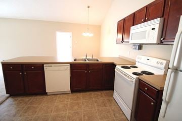 Kent house for rent - a kitchen with white appliances and wooden cabinets