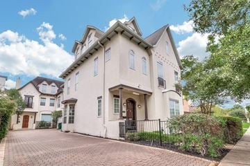 Houston house for rent - the exterior of a white house with a driveway and trees