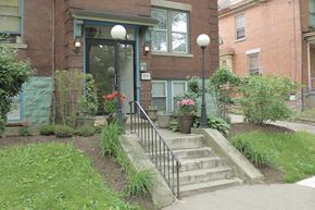 Pittsburgh apartment for rent - A brick house with a green lawn in front.