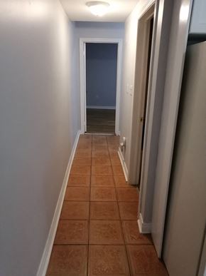 Hamilton apartment for rent - a hallway with a tiled floor and a blue wall and a door