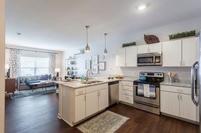 Fairport apartment for rent - a kitchen with an island and a stove and a sink