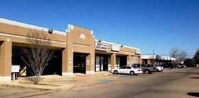 Mesquite apartment for rent - A parking lot in front of a strip mall with a car parked in the lot.