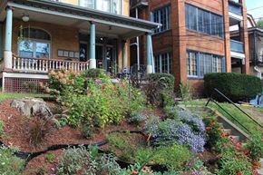 Pittsburgh apartment for rent - a garden in front of a house with a porch