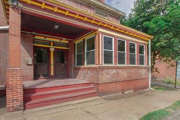 Pittsburgh apartment for rent - A red brick house with a yellow stripe and a red door.