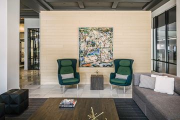 Cleveland apartment for rent - a living room with green chairs and a painting on the wall