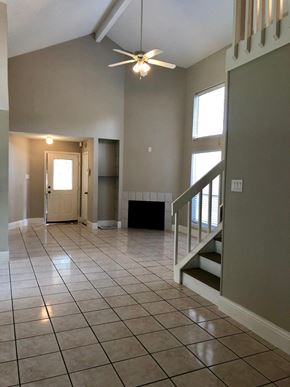 Houston house for rent - an empty living room with a tile floor and a ceiling fan