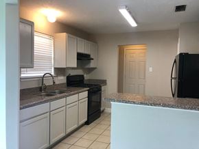Houston house for rent - a kitchen with granite counter tops and black appliances