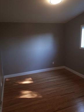 Hamilton house for rent - an empty room with wooden floors and a blue wall