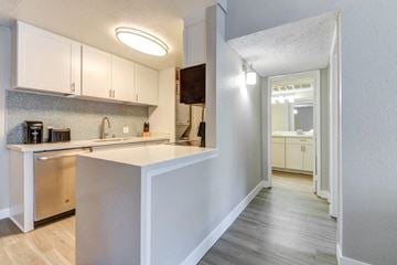 San Diego apartment for rent - A kitchen with white cabinets and a wooden island.