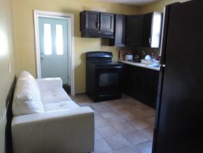 Hamilton apartment for rent - a kitchen with black cabinets and a white couch