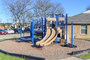Crockett apartment for rent - A playground with a blue and tan slide.