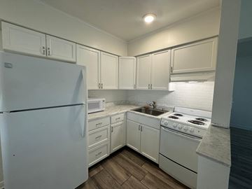 St Petersburg apartment for rent - a kitchen with white appliances and white cabinets