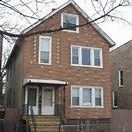 Chicago apartment for rent - A brown brick house with a white door and windows.