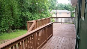 Chapel Hill house for rent - A wooden deck with a railing and a view of a green lawn and trees.