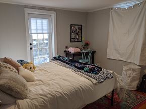Chapel Hill house for rent - A bedroom with a bed covered in a white comforter and a window with blinds.