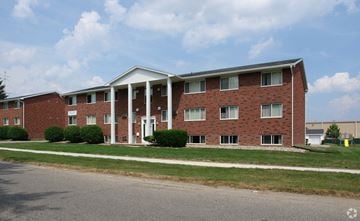 Lansing apartment for rent - A red brick building with a white roof and columns.