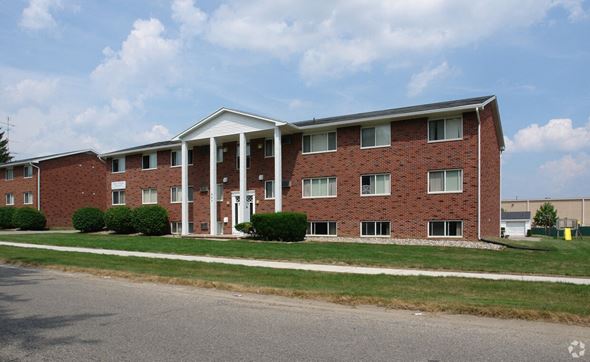 Lansing apartment for rent - A red brick building with a white roof and columns.