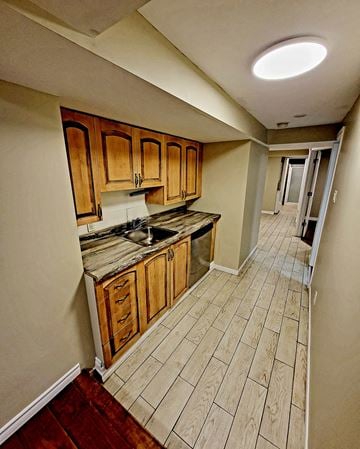 Ottawa apartment for rent - a kitchen with wooden cabinets and a wooden floor