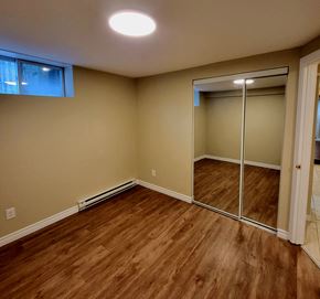 Ottawa apartment for rent - a bedroom with a mirrored closet and a hard wood floor