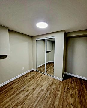 Ottawa apartment for rent - an empty room with wood flooring and mirrored closet doors