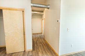South Sioux City apartment for rent - an empty room with a door and a hallway with wood floors and white walls