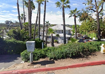 Vista apartment for rent - a house on a street with palm trees and a parking meter