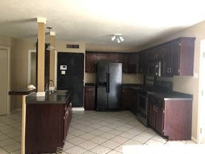 Snyder house for rent - a kitchen with a black refrigerator and a sink