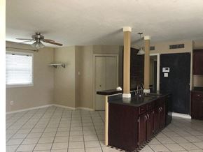 Snyder house for rent - an empty kitchen with a counter and a ceiling fan