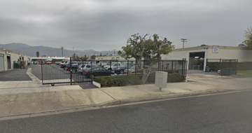Baldwin Park apartment for rent - A parking lot with a black gate and a white sign on a building.