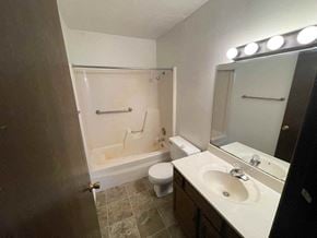 Leonard apartment for rent - A bathroom with a toilet, sink, and bathtub.