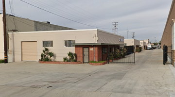 El Monte apartment for rent - A long, narrow building with a red door sits in the middle of a paved lot.