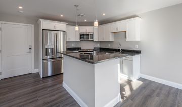 Weymouth apartment for rent - a kitchen with an island and a stainless steel refrigerator