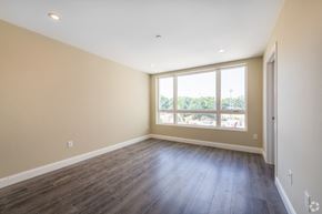 Weymouth apartment for rent - an empty living room with wood floors and a large window