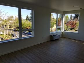 Portland apartment for rent - an empty living room with large windows and a wood floor