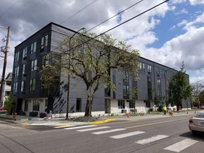 Portland apartment for rent - a large building with a tree in front of it on a city street