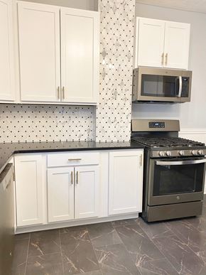 Lakewood house for rent - A kitchen with a black stove top oven and white cabinets.