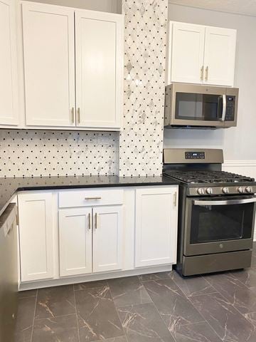 Lakewood house for rent - A kitchen with a black stove top oven and white cabinets.