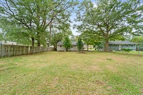 Jacksonville house for rent - A backyard with a fence and trees.