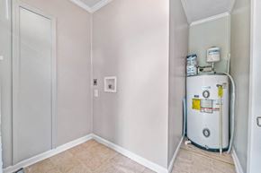 Jacksonville house for rent - A water heater is installed in a corner of a room with white walls and a white door.
