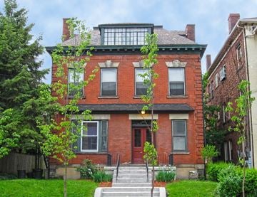 Pittsburgh apartment for rent - A red brick house with a green tree in front.