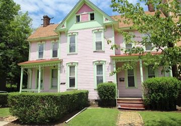Pittsburgh apartment for rent - A pink house with green trim and a red door.