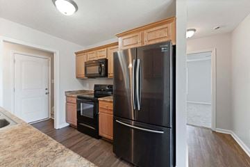 Richlands house for rent - a kitchen with black appliances and wooden cabinets