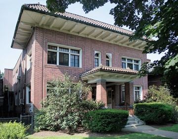 Pittsburgh apartment for rent - a brick apartment building with a porch and bushes