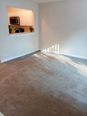 Portland apartment for rent - A room with a carpeted floor and sunlight streaming in through a window.