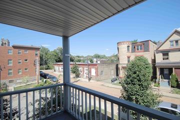 Pittsburgh apartment for rent - A balcony overlooks a parking lot and buildings.