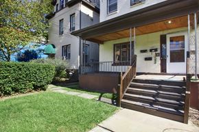 Pittsburgh apartment for rent - A house with a green lawn and a brown wooden fence.