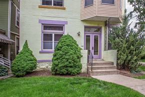 Pittsburgh apartment for rent - A house with a purple door and a green lawn.