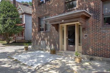 Pittsburgh apartment for rent - A brick building with a brown door and windows.